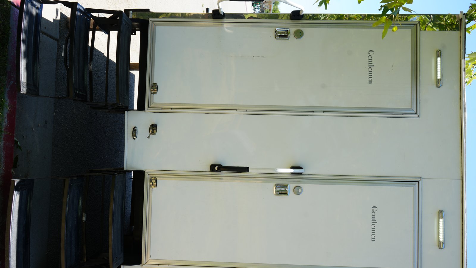 Restroom trailer entry doors with Gentlemen labels